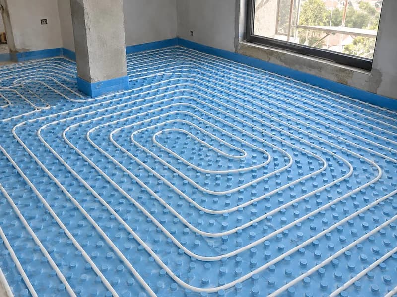 Tubo de piso radiante em espiral sobre placas isolantes azuis